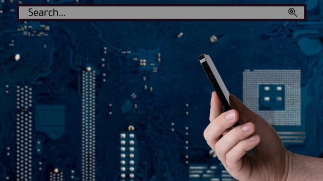 Hand holding a smartphone with a search bar on the screen