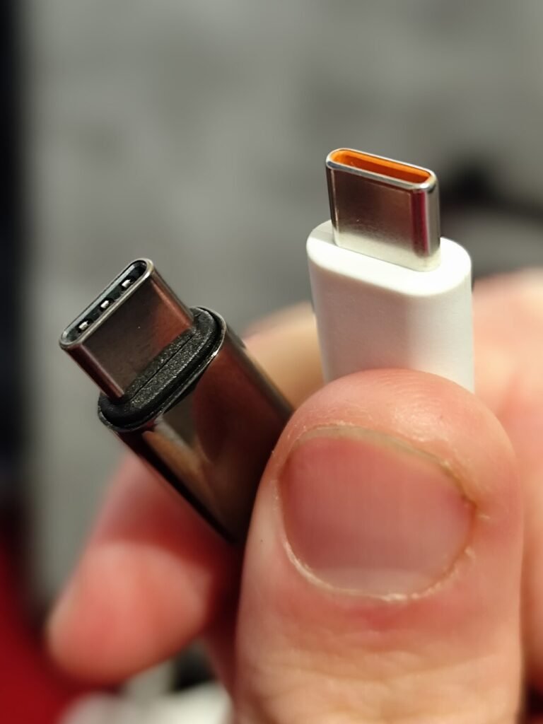 Two USB-C connectors held between fingers