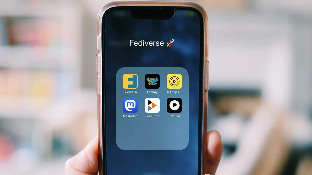 Hand holding a smartphone showing a screen of app icons